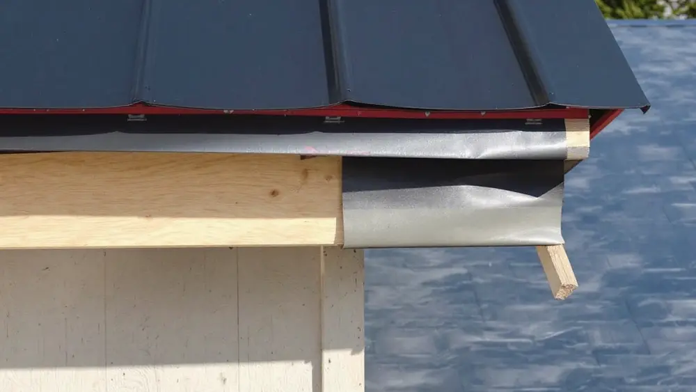 Self-adhered underlayment along a roof eave with the first standing seam metal panels installed above it